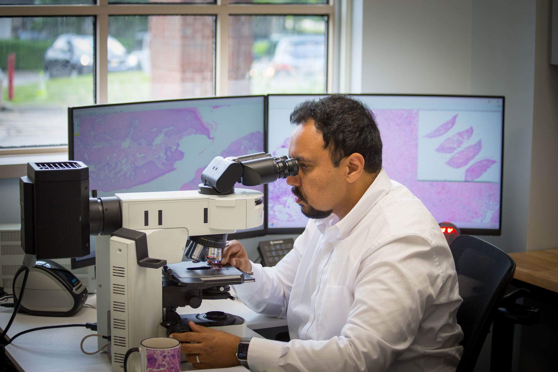 Pathologist examining tissue sample with microscope